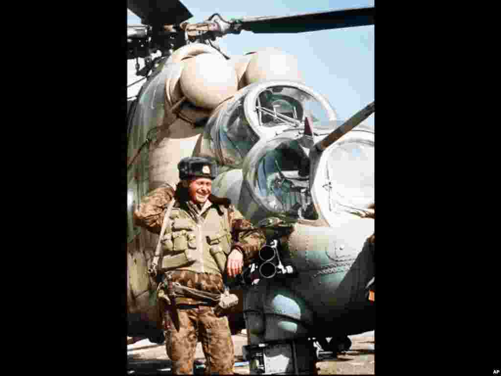 A Soviet soldier puts his arm on the tubes of a MI 24 helicopter's machine gun, at the Soviet military airport in Kabul, Afghanistan, 8 February 1989. Some Soviet troops still remain at Kabul Airport, their mission, apparently, to guard it until the Sovie