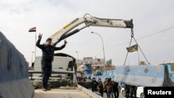 Iraqi security forces lift concrete blockades in order to remove checkpoints in Iraq's capital of Baghdad, Dec. 20, 2016. 