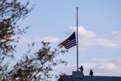 Oficiales de policía del Capitolio bajan la bandera estadounidense a media asta sobre el Capitolio de Estados Unidos para honrar al oficial de policía del Capitolio William Evans, asesinado en el cumplimiento de su deber el 2 de abril de 2021.