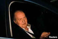 FILE - Spain's King Juan Carlos sits in a car after being released from a hospital after a hip operation in Madrid, Dec. 2, 2012.