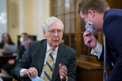 FILE - Senate Minority Leader Mitch McConnell turns to an aide as the Senate Rules Committee holds a hearing on the For the People Act, which would expand access to voting and other voting reforms, at the Capitol in Washington, March 24, 2021.
