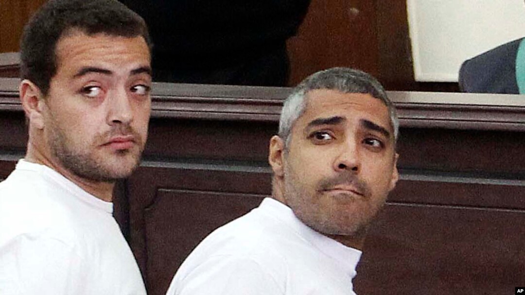 FILE - Al-Jazeera English producer Baher Mohamed, left, and Canadian-Egyptian acting Cairo bureau chief Mohammed Fahmy appear in court during their trial on terror charges, in Cairo, Egypt. 