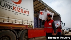 터키 적신월사 요원들이 시리아 이들리브 주에 구호품을 전달하고 있다.