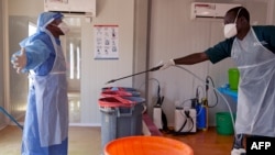 A doctor of International Medical Corps is disinfected at the isolation ward of Ministry of Health Infectious Disease Unit in Juba, South Sudan, April 24, 2020. 