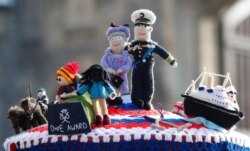 A knitted top cover for a post box depicting Britain's Queen Elizabeth II and her husband, Prince Philip, in Windsor, England, April 16, 2021. It shows some of Philip's favorites: the Royal Yacht Britannia and his hobby of carriage driving.