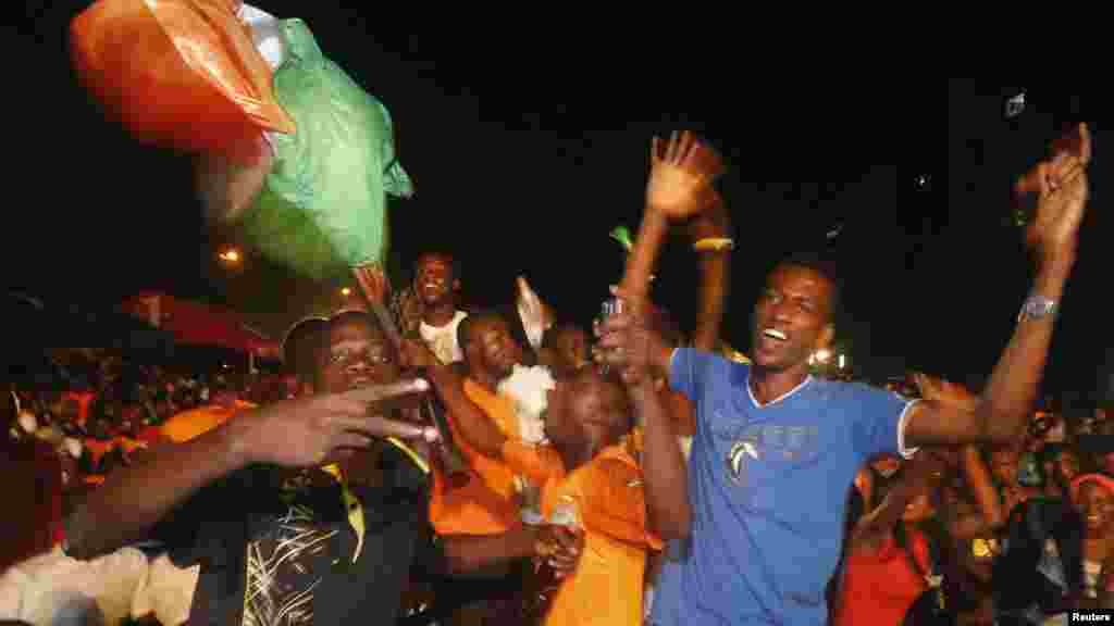 Fans of Ivory Coast's soccer team celebrate their team winning their 2015 African Nations Cup semi-final soccer match against Democratic Republic of Congo, along a street in Abidjan February 4, 2015. Goals from Yaya Toure and Gervinho helped steer Ivory C