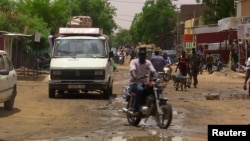 FILE - A man rides a motorcycle down a street in the northern city of Gao, Mali, July 22, 2016.