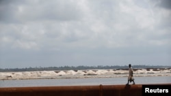 Un homme se promène près d'un oléoduc aux alentours des plages de Akodo, Lagos, le 25 juin 2016.