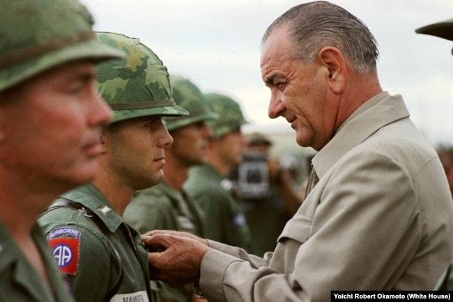 FILE - Johnson awards the Distinguished Service Cross to First Lieutenant Marty A. Hammer, in Vietnam. (LBJ Library)