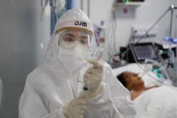A nurse prepares an injection for a COVID-19 patient in the ICU of the National Hospital in Itagua, Paraguay, Sept. 7, 2020.