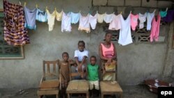 Une famille pose à West Point au Liberia. Les chaises vides représentent le chef de famille et les autres membres de famille emportés par Ebola. EPA/AHMED JALLANZO 