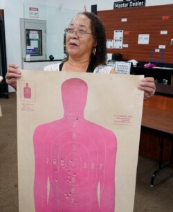 In this Aug. 21, 2021, image taken from video, Valerie Rupert is interviewed at the Recoil Firearms store in Taylor, Mich.