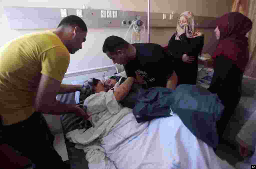 Mohammed al-Bakri brings the body of his three-year-old son Kamal to the boy's wounded mother, Dua, at the Shifa hospital in Gaza City, Aug. 5, 2014. 