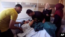 Mohamed al-Bakri donosi telo svog trodošinjeg sina Kamala dečakovoj ranjenoj majci Dui u bolnici Šifa u gradu Gazi. Dečak je ubijen u izraelskom napadu u ponedeljak sa još dvoje članova porodice. 