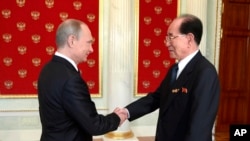 Perezida w'Uburusiya Vladimir Putin, ibubamfu, n'umutegetsi wa Koreya ya ruguru ajejwe gutunganya amanama Kim Yong-nam baramukanya mu nama yabahuje i Moscou, mu Burusiya, itariki 9/05/2015.