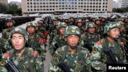 Armed paramilitary policemen stand in Urumqi, the capital of Xinjiang.