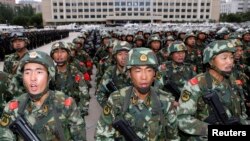Armed paramilitary policemen stand in formation during a gathering to mobilize security operations in Urumqi, Xinjiang Uighur Autonomous Region, June 29, 2013.