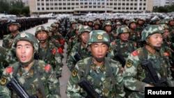Cảnh sát có vũ trang xếp hàng chuẩn bị cho các hành động siết an ninh tại Urumqi, Tân Cương.