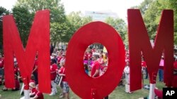 Demonstrators hold letters spelling out "mom" during a rally by Moms Demand Action for Gun Sense in America to protest the National Rifle Association's annual convention a few blocks away in Atlanta, April 29, 2017.