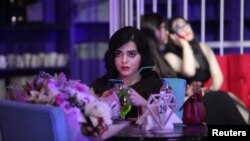 A woman uses her mobile phone at Luxury Time, the city's first women-only restaurant, in Irbil, Iraq, July 17, 2018. 