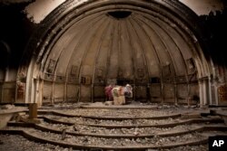 FILE - Remnants of an altar are seen in a Catholic church that was gutted by Islamic State militants, in Hamdaniya, Iraq, Dec. 5, 2016.