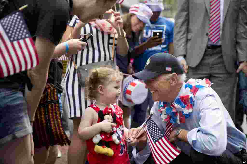 Wakil Presiden Amerika Joe Biden memberikan salam kepada seorang anak kecil ketika ia berada di tengah rombongan pawai parade kemerdekaan di Independence Hall di Philadelphia, Pennsylvania. &nbsp;