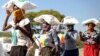 2020年5月20日南非比勒陀利亚劳登郊区附近妇女顶着玉米粉袋