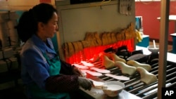 In this Friday, Feb. 1, 2019, photo, a worker tend to her station at Ryuwon Shoe Factory that specializes in sports footwear, in Pyongyang, North Korea. (AP Photo/Dita Alangkara)