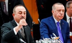 FILE - Turkish President Recep Tayyip Erdogan and Turkish Foreign Minister Mevlut Cavusoglu attend the Libya summit in Berlin, Germany, Jan. 19, 2020.