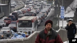 Chinese walk on a pedestrian overhead bridge next to the vehicles driven in heavy traffic in Beijing (File)