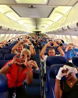 This Friday, March 27, 2020, photo provided by Southwest Airlines employee Dayartra Etheridge shows health care workers, other passengers and flight crew aboard a Southwest flight from Atlanta to New York's LaGuardia Airport.