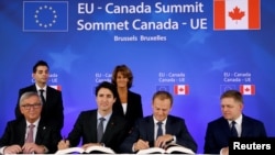 (L-R) European Commission President Jean-Claude Juncker, Canada's Prime Minister Justin Trudeau, European Council President Donald Tusk and Slovakia's Prime Minister Robert Fico attend the signing ceremony of the Comprehensive Economic and Trade Agreement