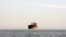 A cargo ship is seen between the Iranian city port of Bandar Abbas and Qeshm Island in the strategic waterway the Persian Gulf.