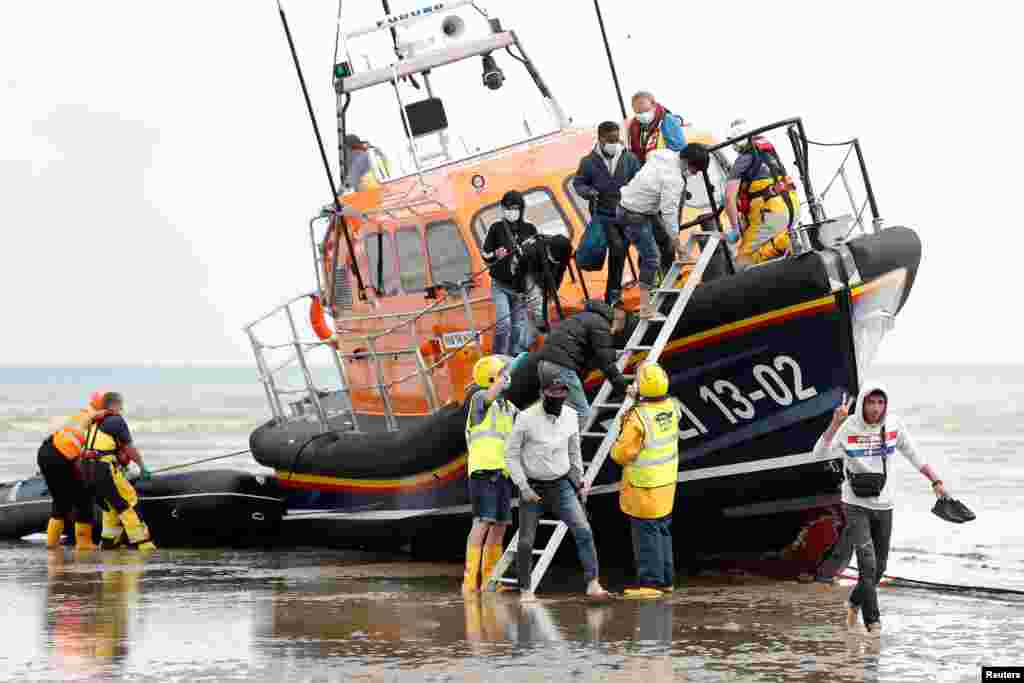 Migrants from nations including Vietnam, Iran and Eritrea disembark a RNLI vessel after being rescued in the English Channel, following their departure from northern France, in Dungeness, Britain.