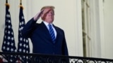 FILE PHOTO: U.S. President Donald Trump poses without face mask as he returns to the White House after being hospitalized at Walter Reed Medical Center for coronavirus disease (COVID-19), in Washington