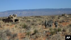 FILE - Soldiers proceed toward armored vehicles after a training exercise at Fort Bliss, Texas, Jan. 23, 2013. The base is one of three Texas military properties being considered as shelter sites for unaccompanied migrant children.