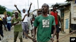 Para demonstran, sebagian membawa parang dan batu, berteriak ketika polisi membuka barikade di Kanyosha, sebuah distrik di Bujumbura, Burundi, 6 Mei 2015. 