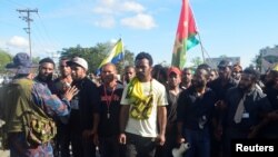 Seorang polisi Papua Niugini (kiri) mengimbau para mahasiswa agar tidak melanjutkan aksi demo mereka di Universitas Papua Nugini, Port Moresby (8/6).