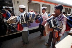 Dabbawala (pengantar kotak makan siang), naik kereta lokal untuk mengantarkan makan siang kepada para pelanggan mereka di Mumbai, India, 2 November 2012. (Foto: AP / Rajesh Kumar Singh)