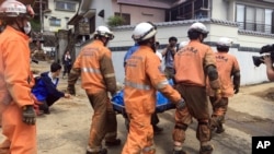 2018年7月9日星期一，日本广岛紧急救援队在暴雨中找回受害者的尸体。