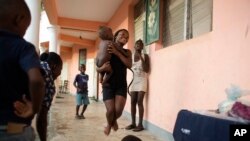 Haitianos que perdieron sus casas en el huracán Matthew se distraen en la escuela donde se refugiaron en el pueblo de Mersan, distrito de Les Cayes, Haití. Domingo 16 de octubre, 2016.