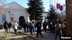 FILE - Students and police are seen in the courtyard of the Dean's Office at the University of Pristina, Feb. 3, 2014. On Wednesday, a letter, allegedly threating an attack by IS, was found in the school as it marked its 47th anniversary.