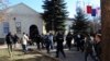 FILE - Students and police are seen in the courtyard of the Dean's Office at the University of Pristina, Feb. 3, 2014. On Wednesday, a letter, allegedly threating an attack by IS, was found in the school as it marked its 47th anniversary.