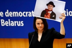 FILE - Belarusian opposition politician Sviatlana Tsikhanouskaya holds a picture of Belarusian opposition activist Nina Baginskaya as she speaks during the Sakharov Prize ceremony at the European Parliament in Brussels, Dec. 16, 2020.