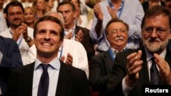 Pablo Casado reacts after being elected the new leader of Spain's conservative People's Party as former Spanish Prime Minister Mariano Rajoy applauds, in Madrid, July 21, 2018. 