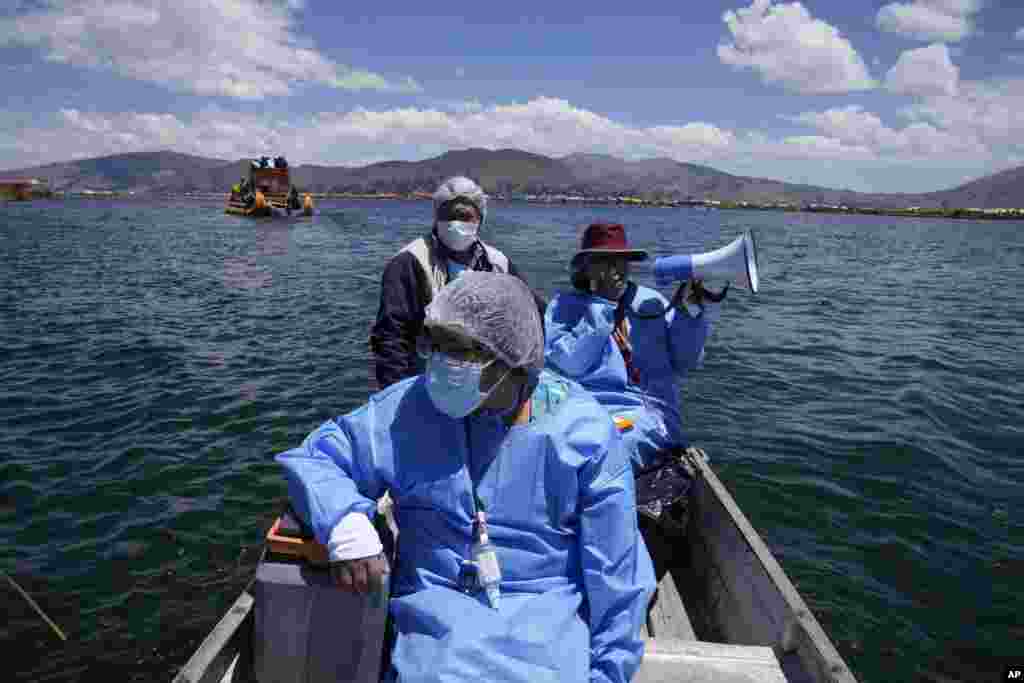 Healthcare workers travel on a boat with coolers containing doses of the Pfizer COVID-19 vaccine as part of a a door-to-door vaccination campaign aimed at Lake Titicaca residents in Puno, Peru, Oct. 27, 2021.