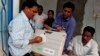 An election officer signs a piece of paper on an electronic voting machine before submitting it at a strong room in Kandhamal district, in the eastern Indian state of Orissa, April 10, 2014