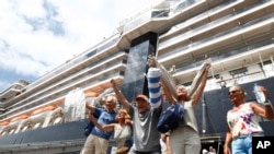 Sebagian penumpang kapall pesiar MS Westerdam meluapkan kegembiraan mereka saat diperbolehkan merapat di pelabuhan Sihanoukville,Kamboja, 14 Februari 2020. (Foto: dok).