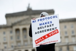 A man holds a sign, as pro-British unionists demonstrate near Parliament buildings, amid nightly outbreaks of street violence in the region that have left dozens of police officers injured, in Belfast, Northern Ireland, April 8, 2021.