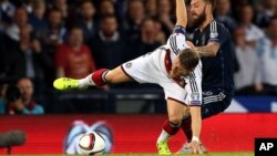 Le capitaine de l'Allemagne Bastian Schweinsteiger, à gauche, aux prises avec Steven Fletcher de l'Ecosse, à droite, au cours du match du Groupe D de l'Euro 2016 à Hampden Park, Glasgow, en Écosse, 7 septembre 2015.